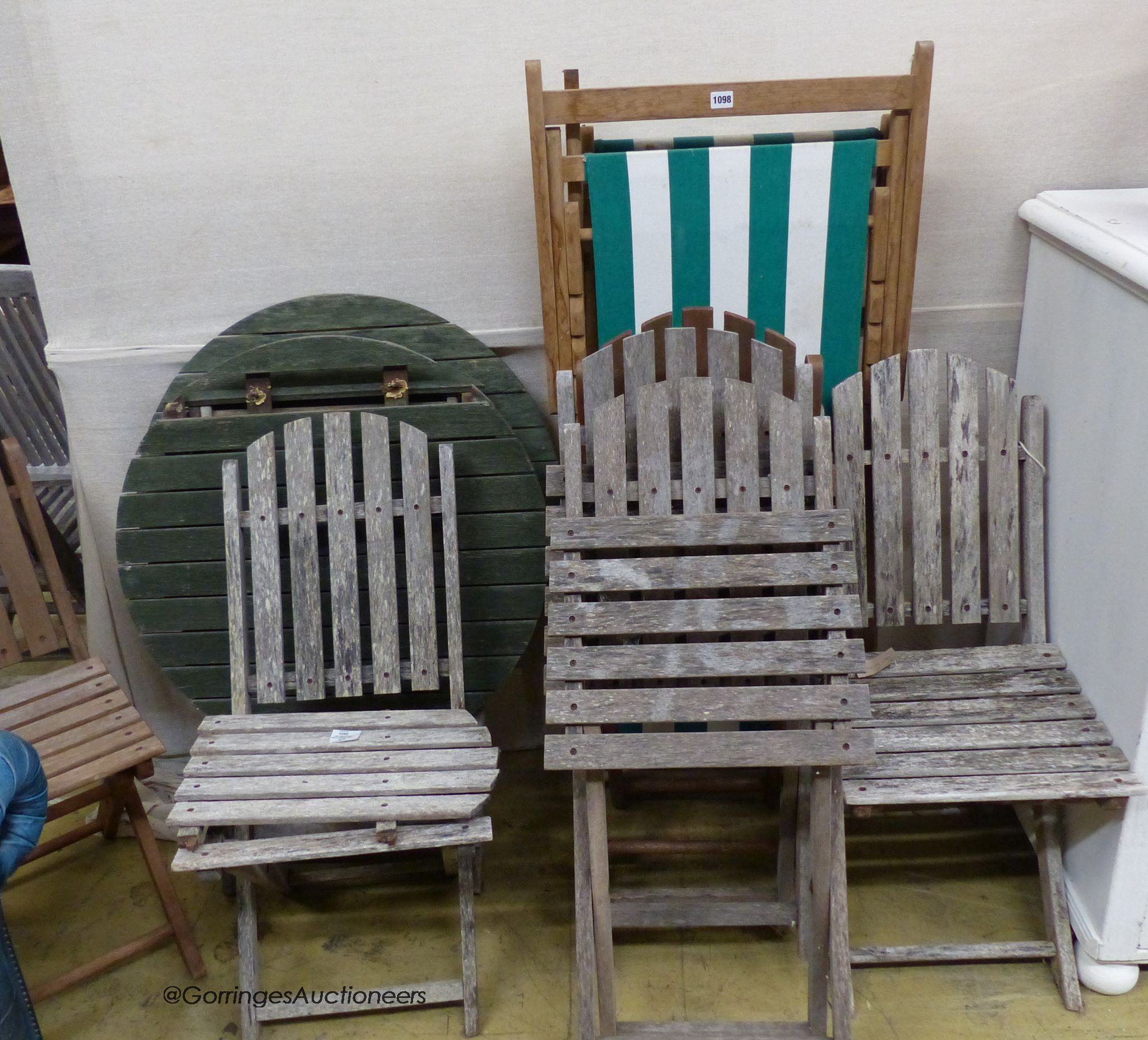 Six assorted weathered teak folding garden chairs, two similar circular tables and a deck chair.